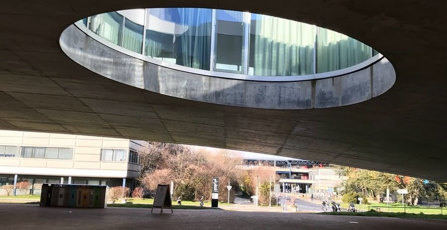 people walking on gray concrete pavement near gray building during daytime